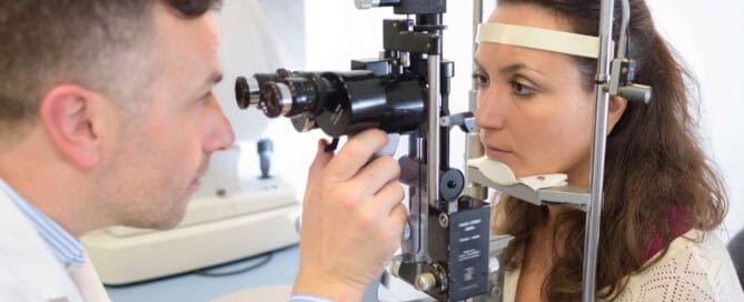 Augenarzt untersucht Frau mit einem augenärztlichen Gerät